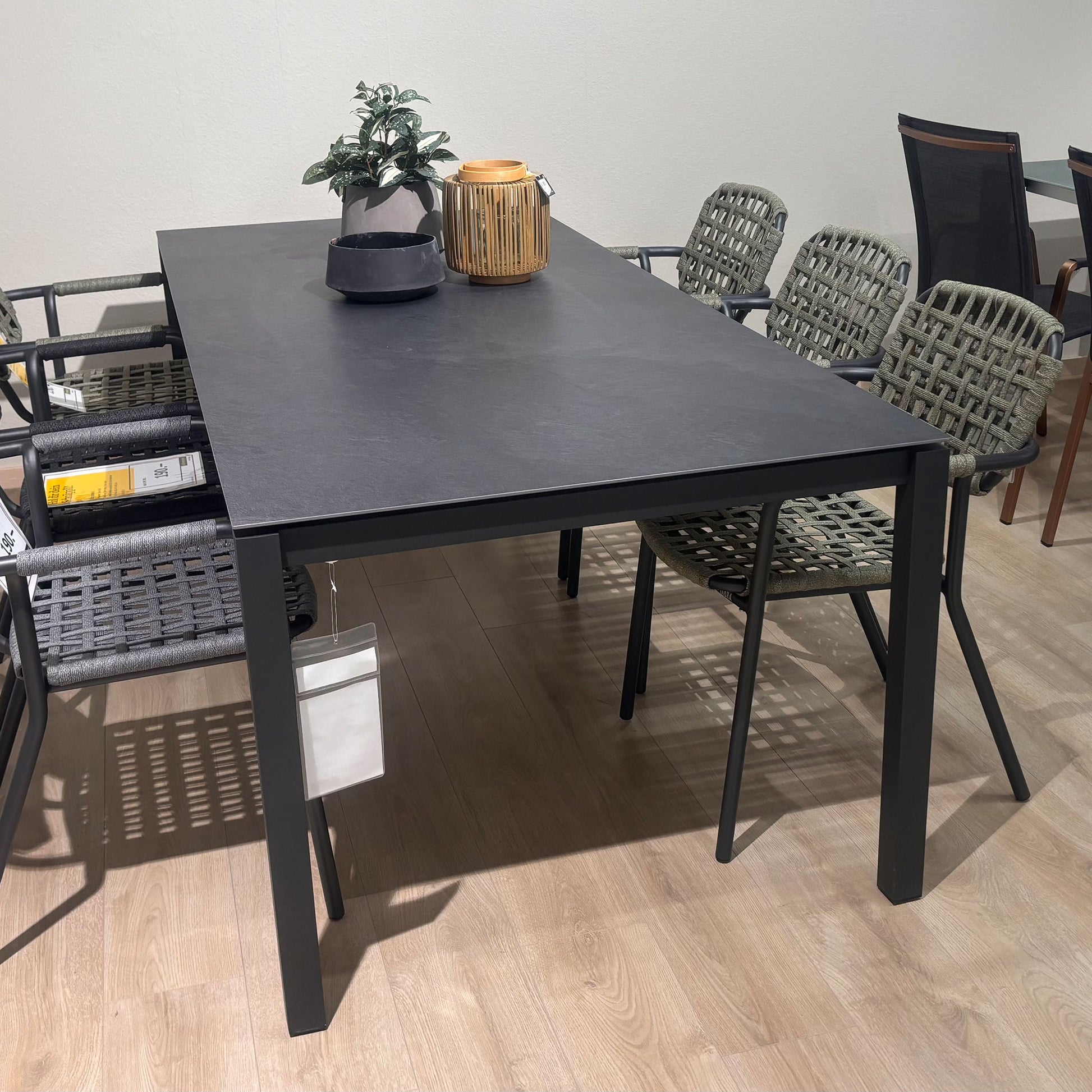 schwarzer Gartentisch mit olivefarbenen Gartenstühlen in ausstellung