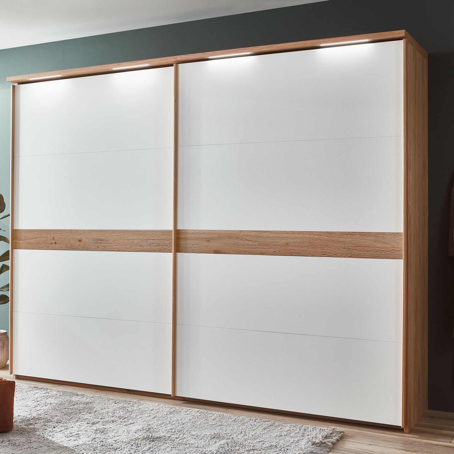 weisser schrank mit zwei schwebetüren und holz und beleuchtung