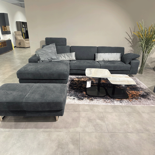 graues Ledersofa mit Hocker und Salontischen