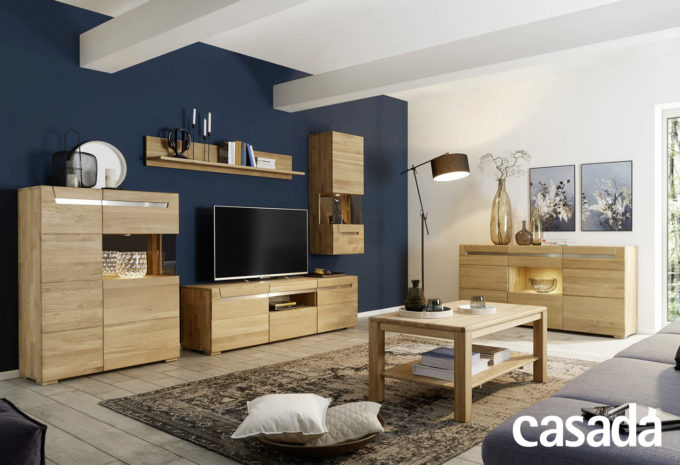 Wohnzimmermöbel in Holzoptik in einem Modernen Wohnzimmer und einer dunkelblauen Wand