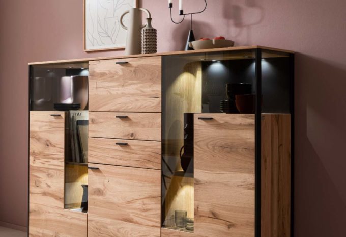 Ein Highboard aus Holz mit Glasakzenten und einer eleganten Beleuchtung